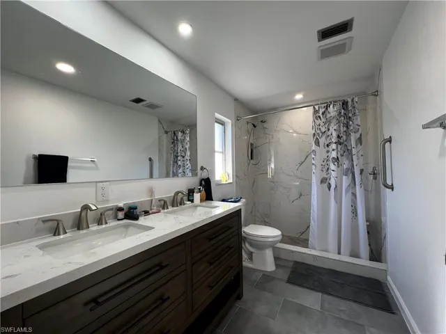 Master Bathroom with vanity, toilet, and walk in shower