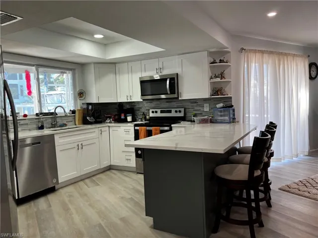 Kitchen featuring light stone counters and stainless-steel appliances