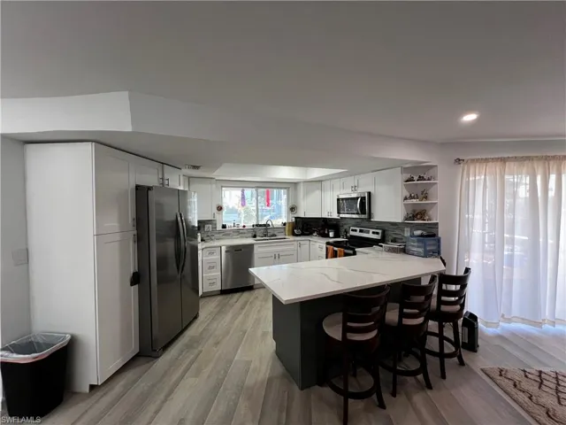 Kitchen featuring sink, a kitchen breakfast bar, stainless steel appliances, and kitchen peninsula