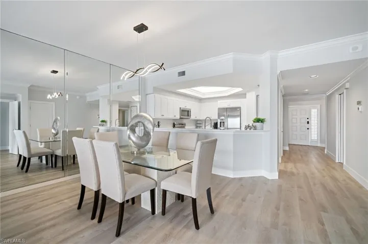 Dining area featuring ornamental molding and light wood-type flooring