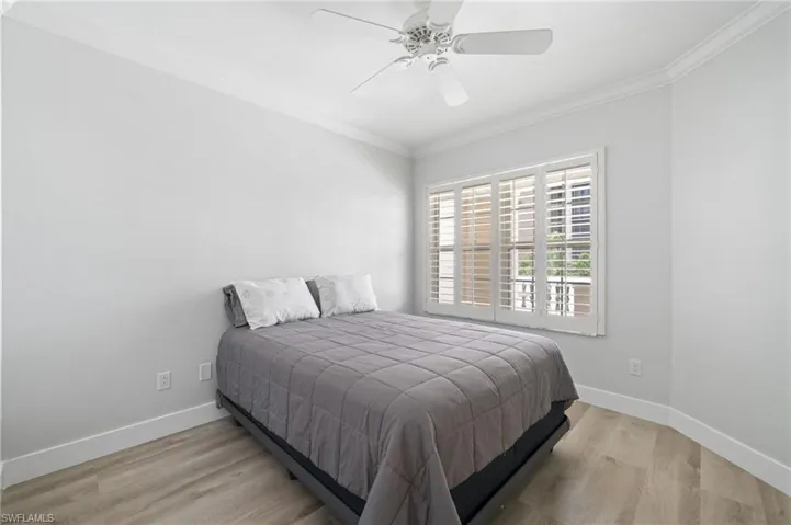 Bedroom featuring ornamental molding, light wood finished floors, and ceiling fan
