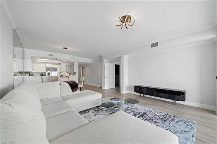 Living room featuring crown molding and light wood-type flooring