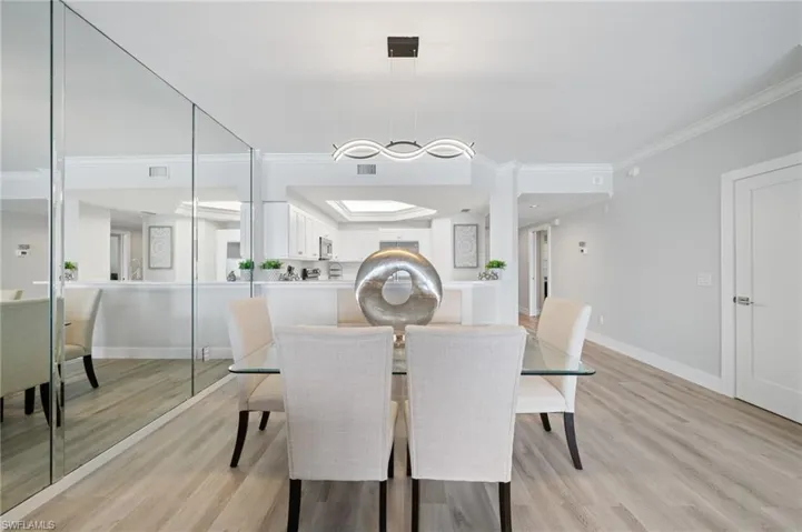 Dining space featuring light wood finished floors and crown molding