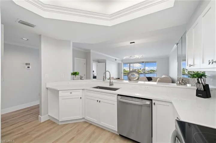 Kitchen featuring stainless steel dishwasher, crown molding, white cabinetry, electric range, and light stone countertops