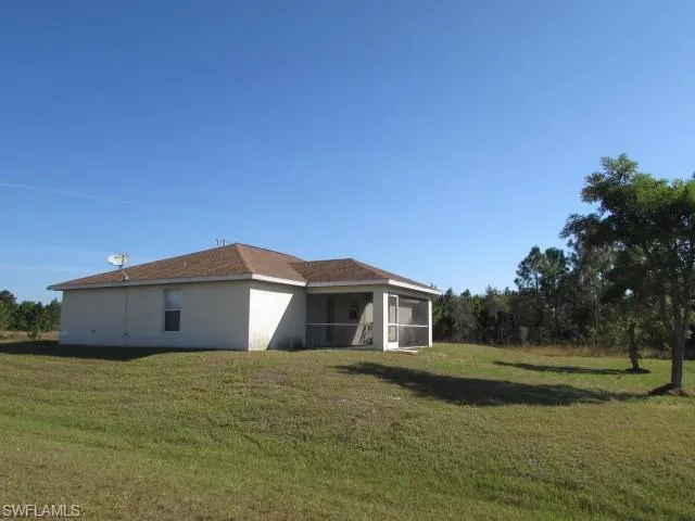 View of side of home featuring a sunroom and a lawn