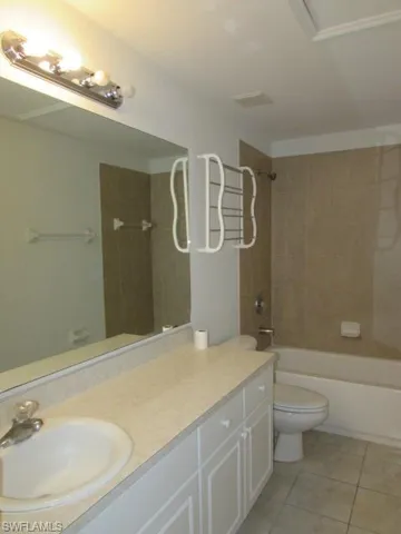 Full bathroom with shower / washtub combination, vanity, and light tile patterned floors