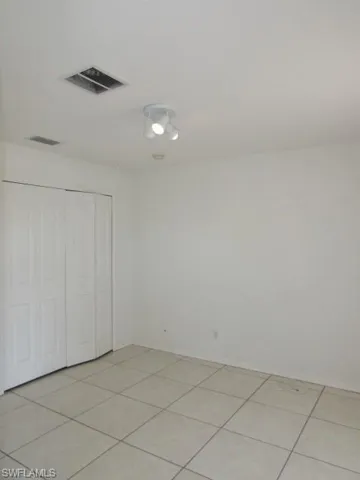 Unfurnished bedroom with light tile patterned flooring and a closet