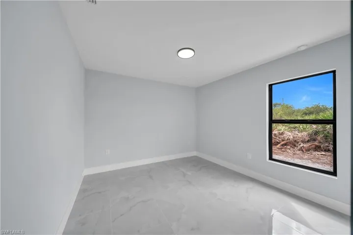 Spare room with baseboards and light marble finish flooring