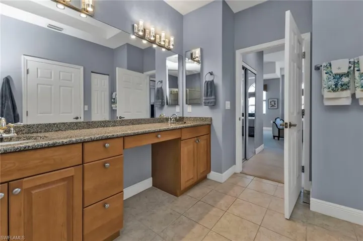 Full bath featuring double vanity, tile patterned flooring, a sink, and visible vents
