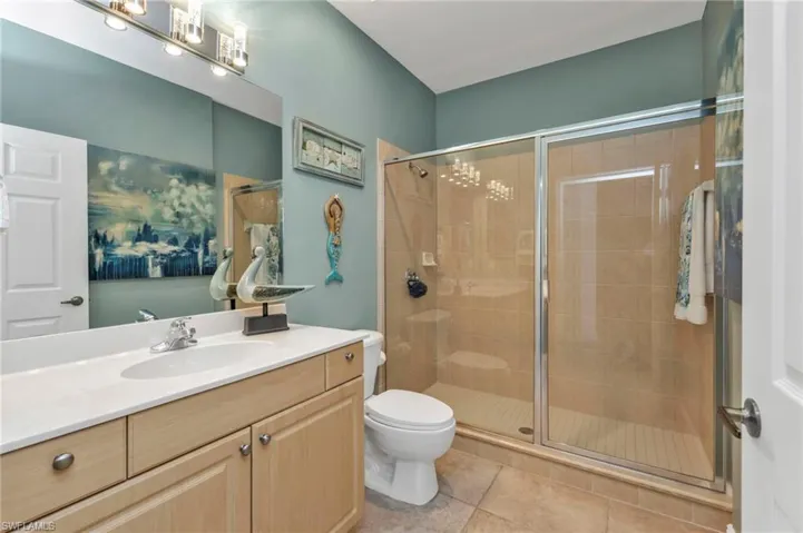 Bathroom with vanity, tile patterned flooring, a shower stall, and toilet