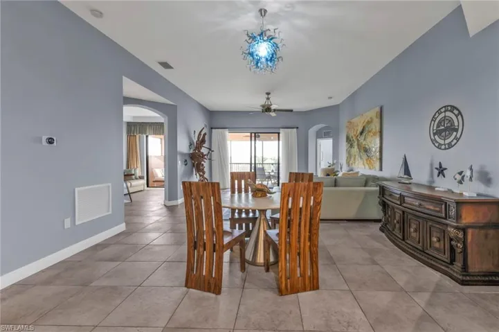 Dining room featuring arched walkways, visible vents, and baseboards