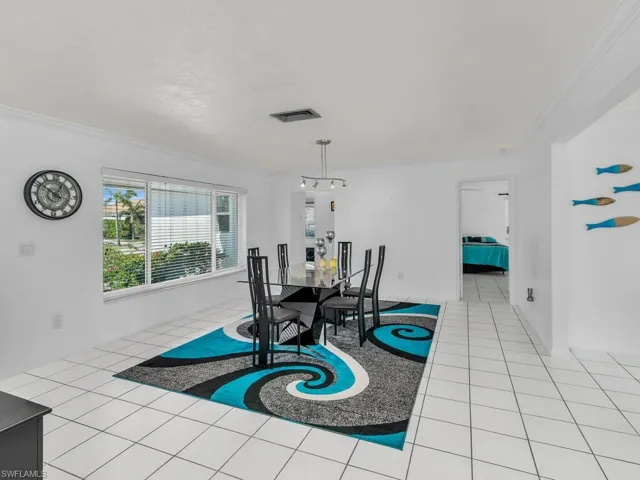 Dining space with light tile patterned flooring, crown molding, and visible vents