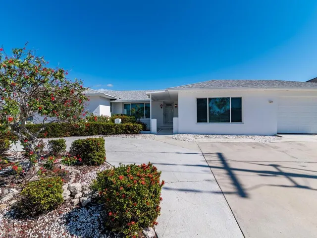 Single story home with a garage, roof with shingles, concrete driveway, and stucco siding