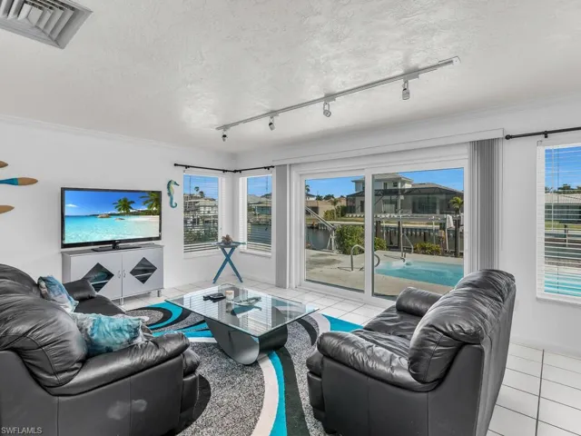 Living area featuring a healthy amount of sunlight, light tile patterned floors, visible vents, and a textured ceiling