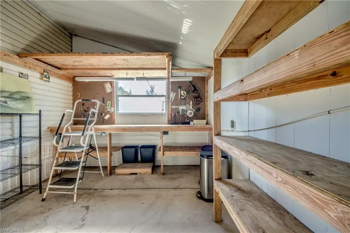 The property includes a spacious utility area featuring a workbench, built-in shelving, and a window providing natural light