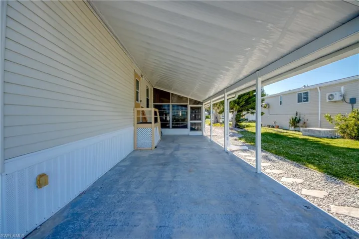 The property features an extensive covered concrete patio, offering a screened-in area for added comfort