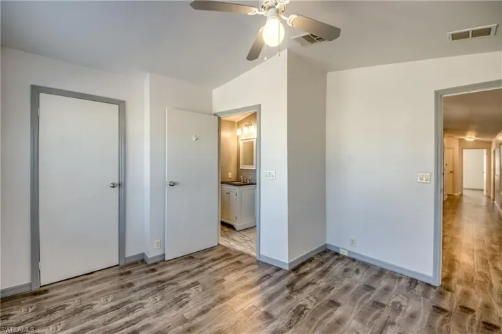 Room featuring wood-look flooring, light-colored walls, and a ceiling fan with integrated lighting