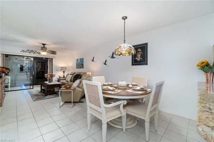 Dining space with ceiling fan and light tile patterned flooring