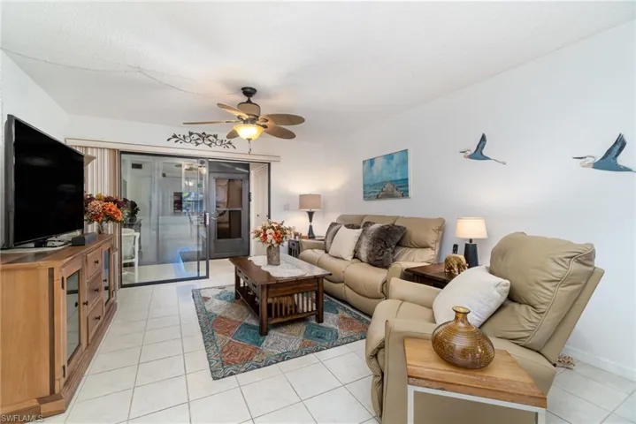 Living room featuring light tile patterned floors and ceiling fan