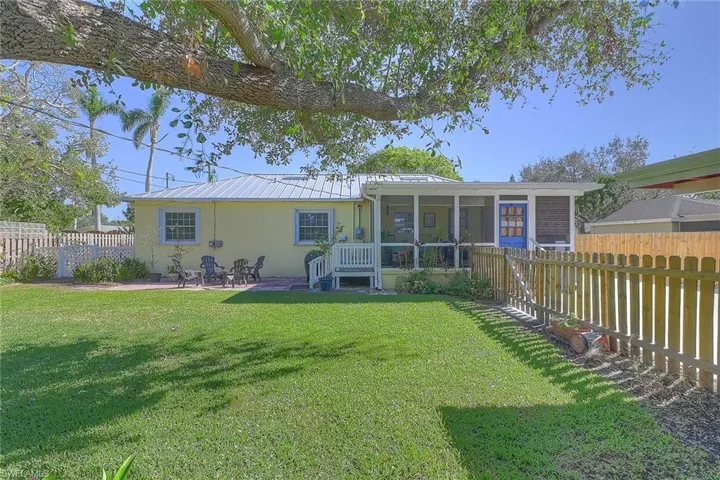 Rear view of property featuring a patio, a lawn, and a sunroom