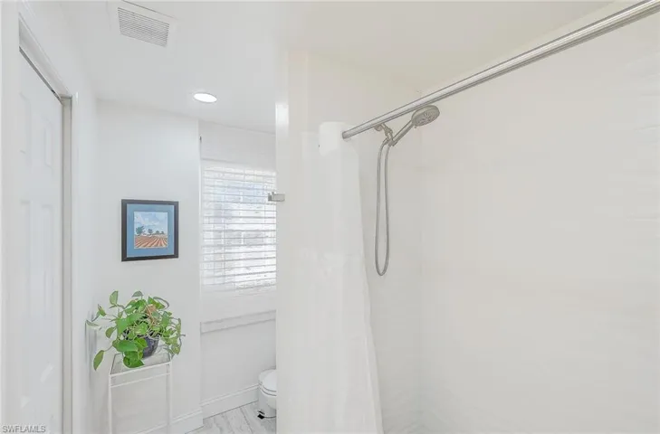 Bathroom with a shower with curtain and toilet