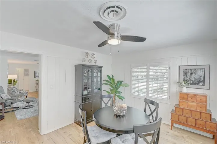 Dining room featuring light hardwood / wood-style floors, ceiling fan, and wooden walls