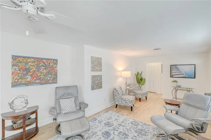 Living area with ceiling fan and light wood-type flooring