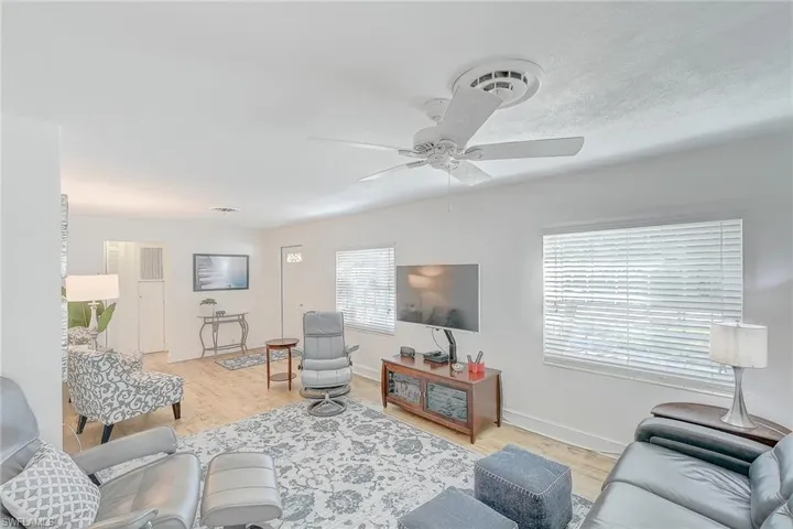 Living room with light wood-type flooring and ceiling fan