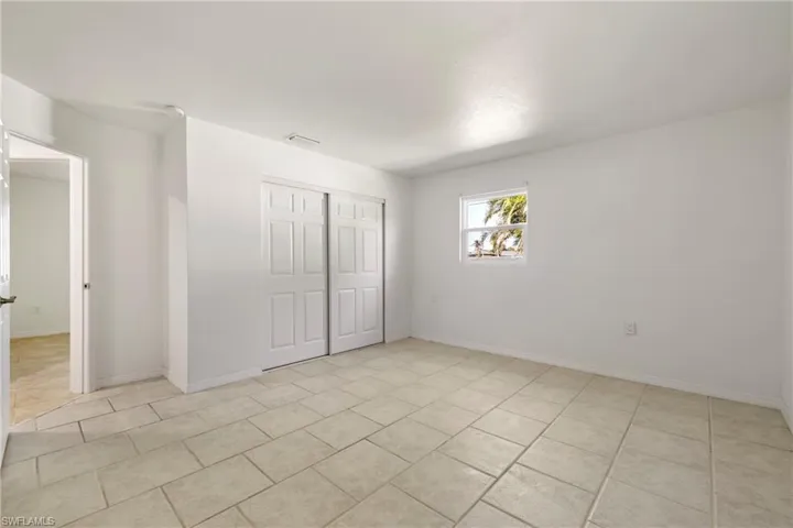 Unfurnished bedroom with a closet, visible vents, baseboards, and light tile patterned floors