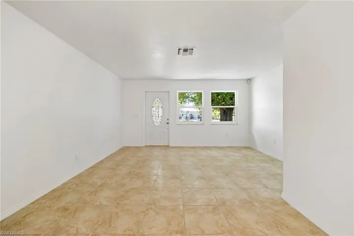 Foyer entrance with baseboards, visible vents, and light tile patterned flooring
