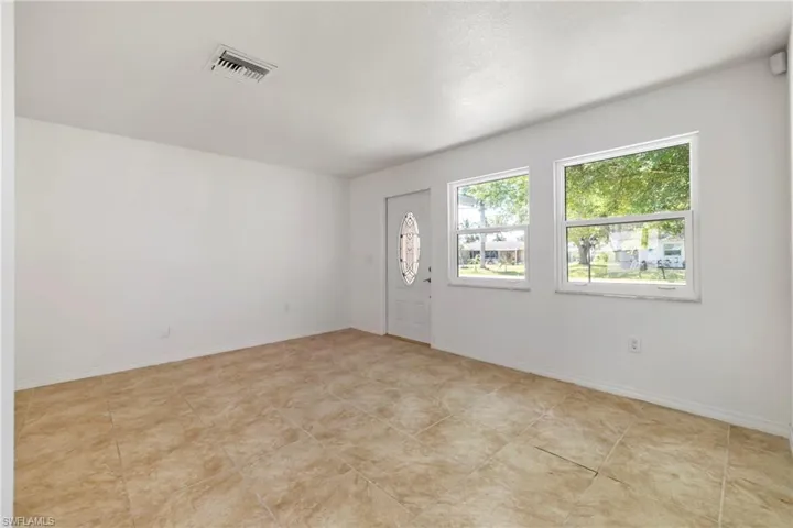 Empty room with baseboards and visible vents