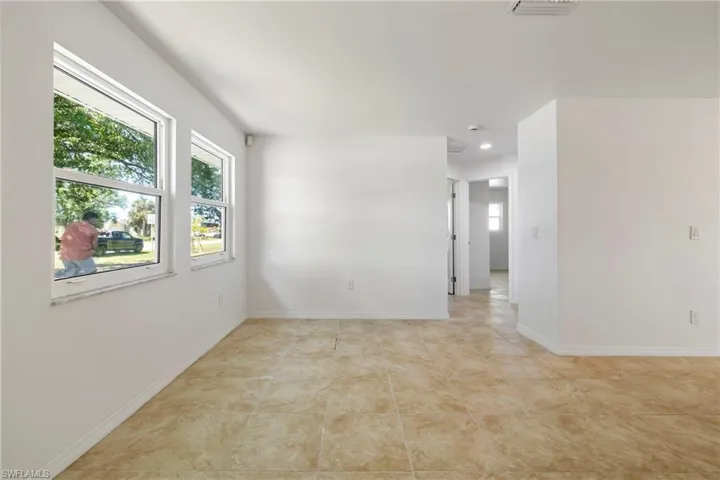 Empty room featuring light tile patterned flooring, baseboards, visible vents, and recessed lighting