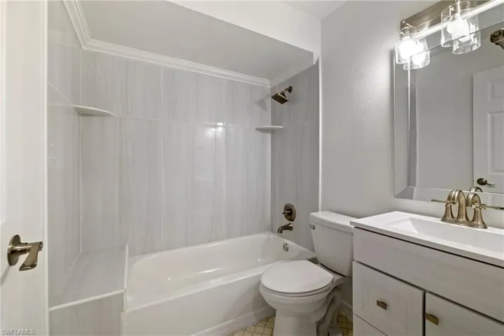 Full bath with tub / shower combination, toilet, and vanity