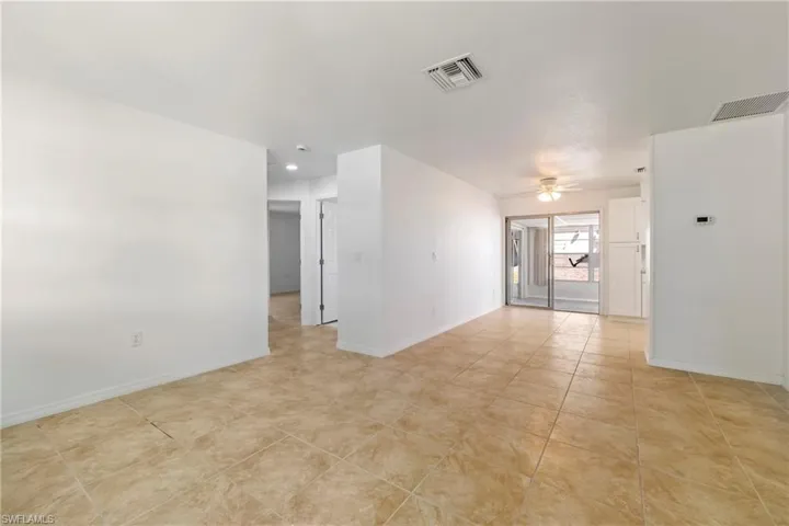 Spare room featuring light tile patterned floors, baseboards, ceiling fan, and visible vents