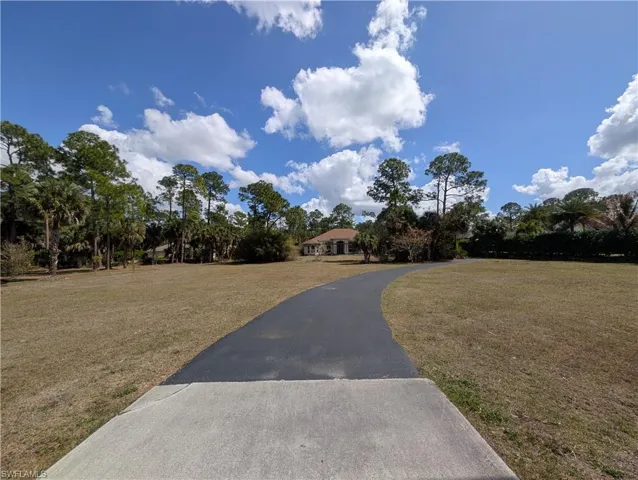 View of front of house featuring a front yard and asphalt driveway