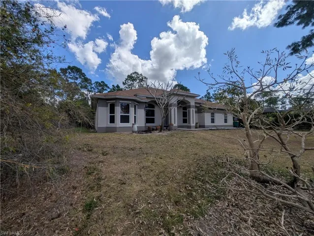 View of front of house featuring a patio, a front yard, and stucco siding