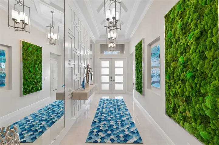 Entrance foyer featuring french doors, a high ceiling, tile patterned flooring, and ornamental molding