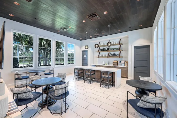 Bar area with open shelves, light stone counters, hanging light fixtures, wooden ceiling, and recessed lighting