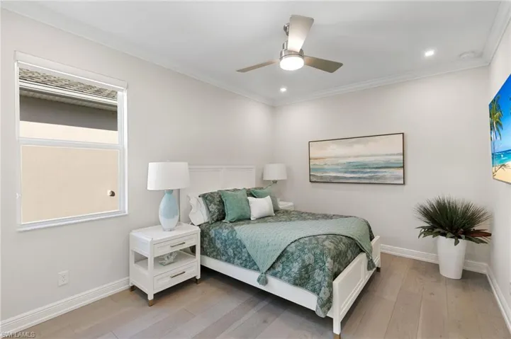 Bedroom with light wood-type flooring, ceiling fan, ornamental molding, and recessed lighting