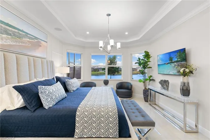 Bedroom with a raised ceiling, ornamental molding, a chandelier, and recessed lighting