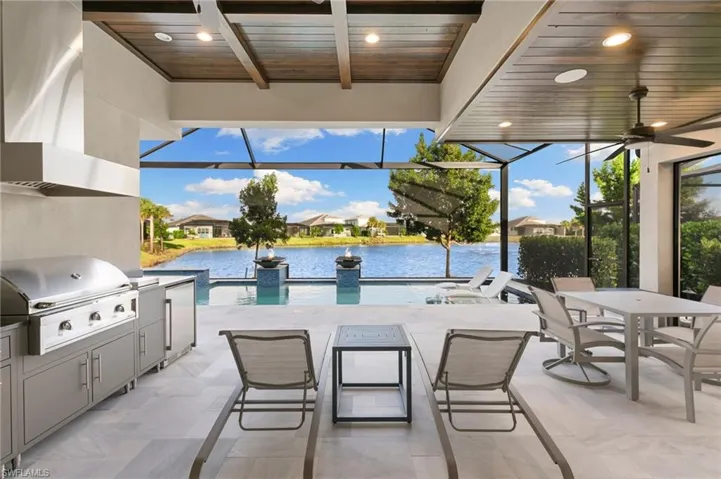 View of patio / terrace featuring a sunroom, glass enclosure, outdoor dining area, and ceiling fan