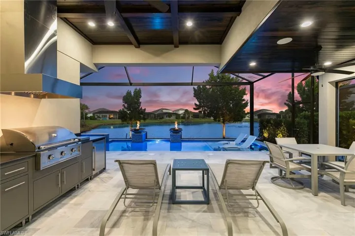 Swimming pool featuring outdoor dining space, area for grilling, a patio area, a lanai, and a sunroom