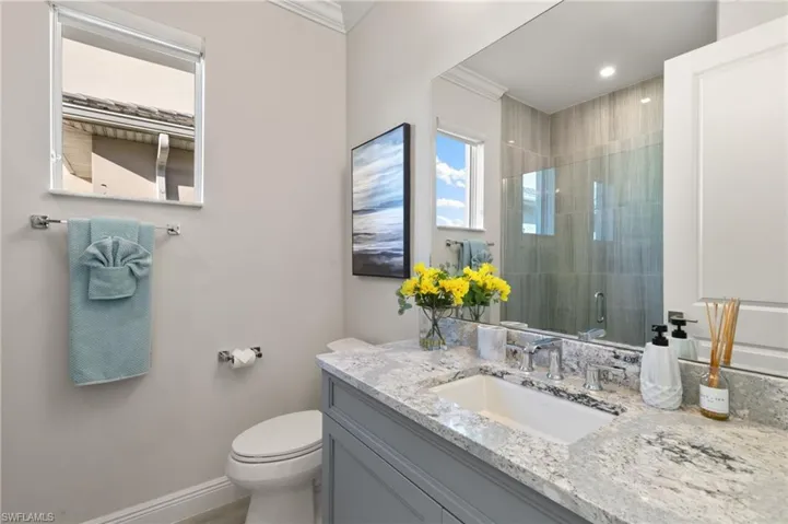 Bathroom with a stall shower, vanity, and crown molding