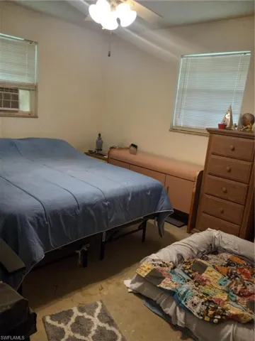 Carpeted bedroom with cooling unit and ceiling fan