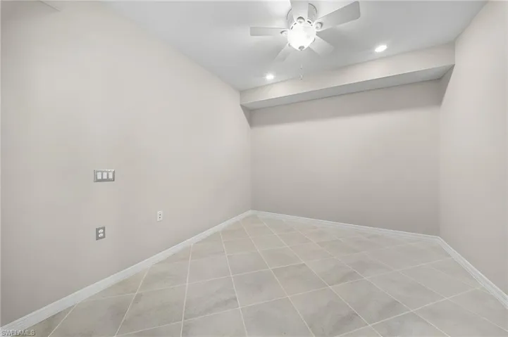 Recessed lighting, ceiling fan, neutral wall color, tile flooring, and white trim