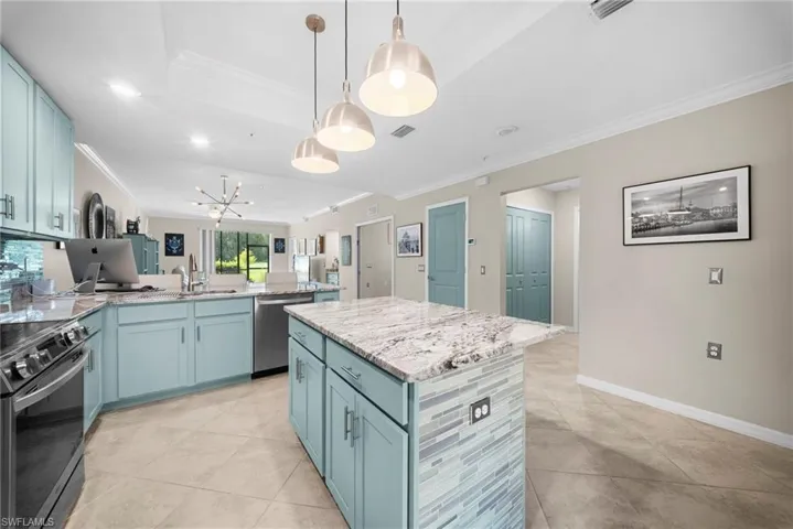 Kitchen featuring light blue cabinetry, stainless steel appliances, a center island with a tile backsplash, and recessed lighting