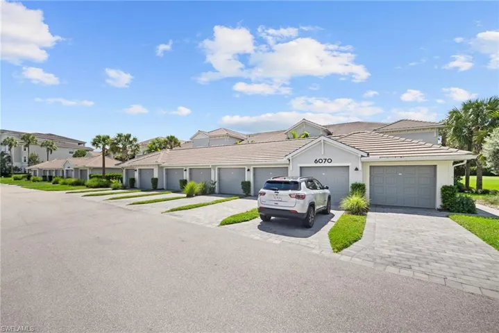 Exterior featuring a tile roof, stucco finish, paver driveways, and integrated garage doors