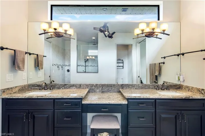 Bathroom featuring tiled shower and vanity