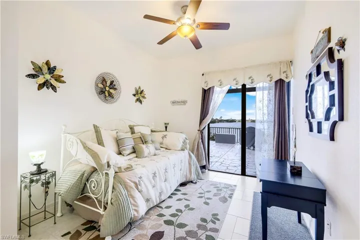 Bedroom featuring ceiling fan, light tile patterned floors, and access to outside