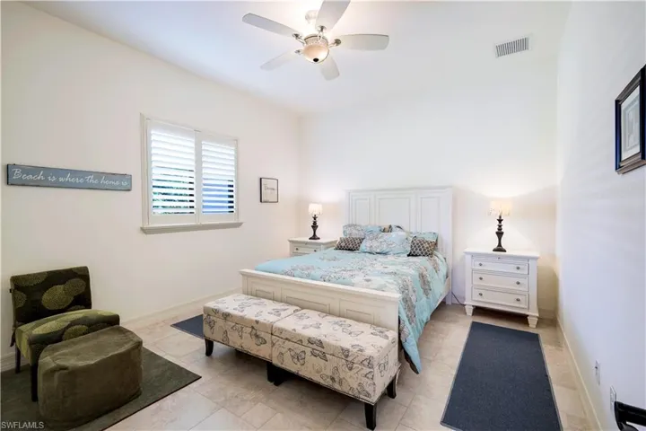 Bedroom with ceiling fan and light tile patterned floors